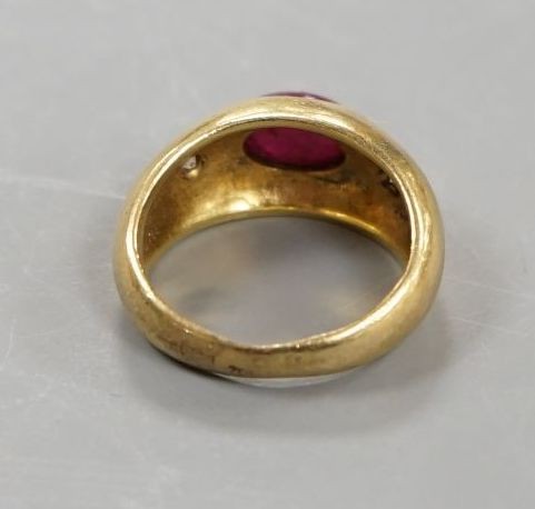 A yellow metal, cabochon ruby and two stone diamond chip set ring, size E/F, gross weight 6.6 grams.